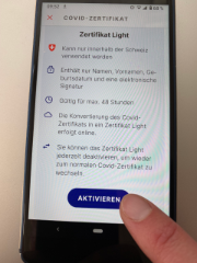 Photo d'un écran de portable affichant le certificat light et un doigt qui touche l'écran